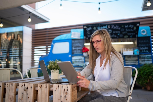 Femme avec une tablette travaillant dans un café