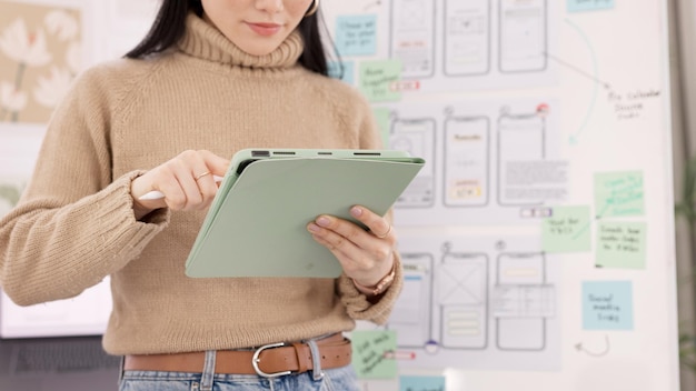 Femme tablette et ui ux design avec le développeur créatif pour le projet d'application mobile avec un stylo au bureau