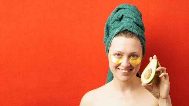 Une femme avec des taches sous les yeux tient un avocat dans sa main