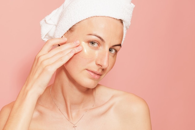 Femme avec des taches sous les yeux touchant sa peau lisse