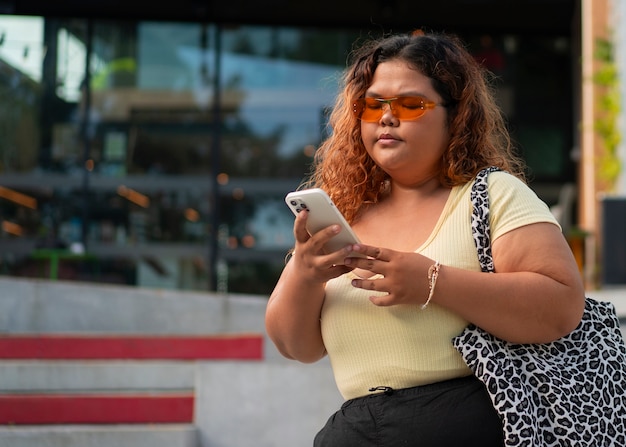 Photo femme de taille moyenne posant à l'extérieur