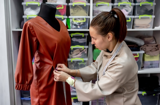 femme tailleur ou créateur de mode prenant des mesures de robe de créateur