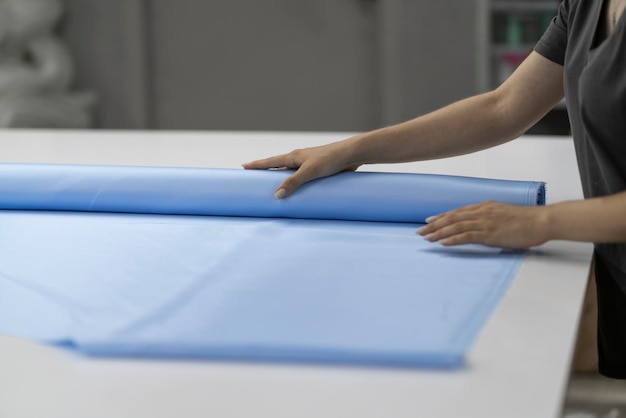 Photo une femme tailleur tenant des rouleaux de tissus écologiques dans l'atelier