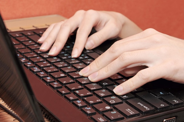 Une femme tapant sur un clavier avec le mot « ordinateur » en bas à droite.