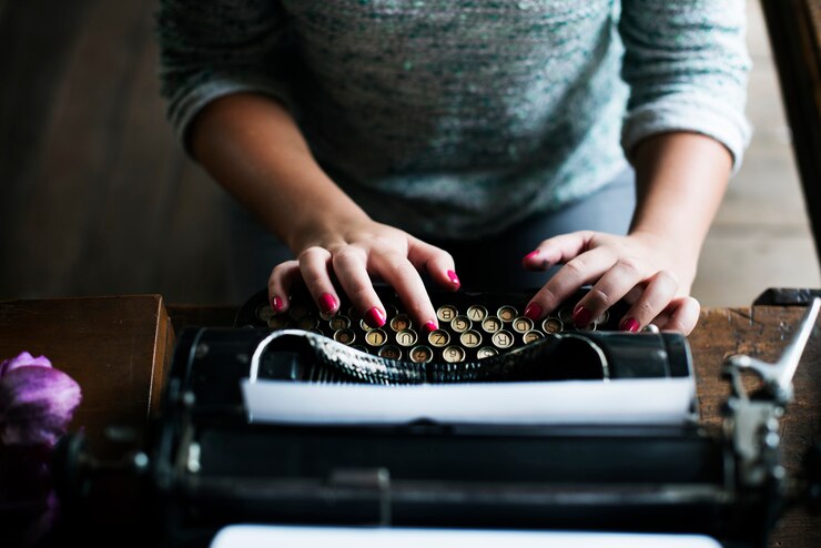 Photo femme en tapant une machine à écrire vintage sur une table en bois