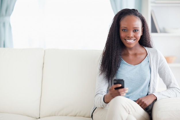 Femme, tapant un message texte sur le canapé