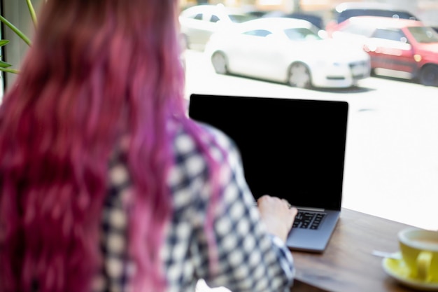 Femme tapant sur un ordinateur portable avec écran vide avec espace de copie pour votre texte ou contenu publicitaire assis...