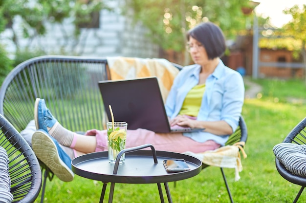 Femme tapant sur l'ordinateur portable pour le travail à distance