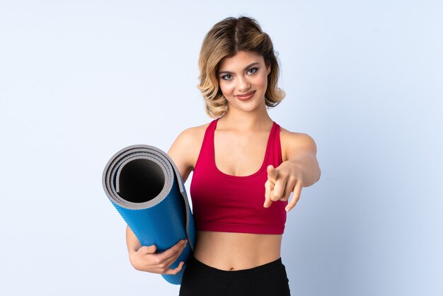 Femme avec tapis de sport en studio