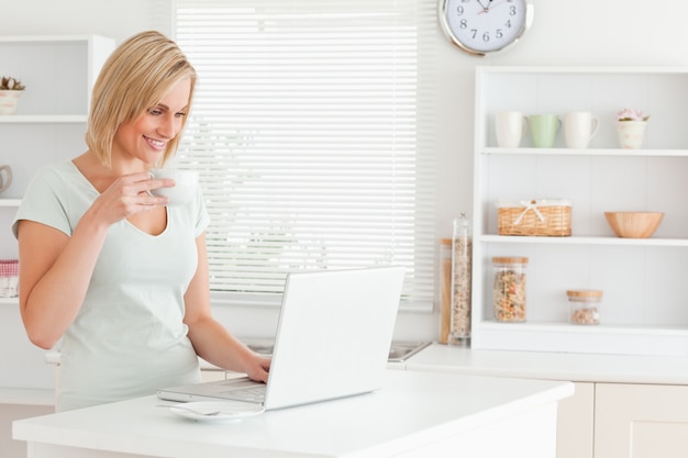 Femme avec une tasse de café et un ordinateur portable