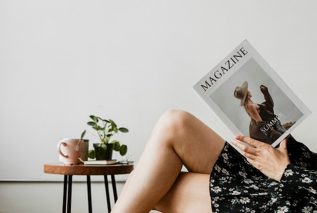 Femme avec une tasse de thé en lisant un magazine