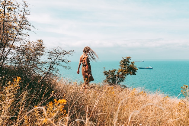 femme tatouée avec des dreadlocks blondes en mer voyage et mode de vie