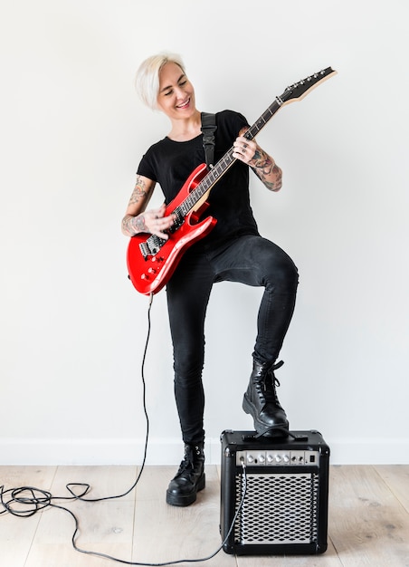 Femme tatouée jouant de la guitare électrique