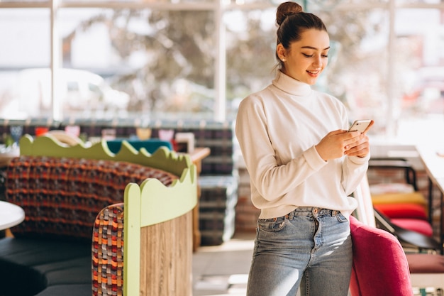 Femme avec un téléphone dans un café