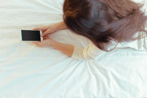 Femme avec un téléphone mobile moderne dans les mains