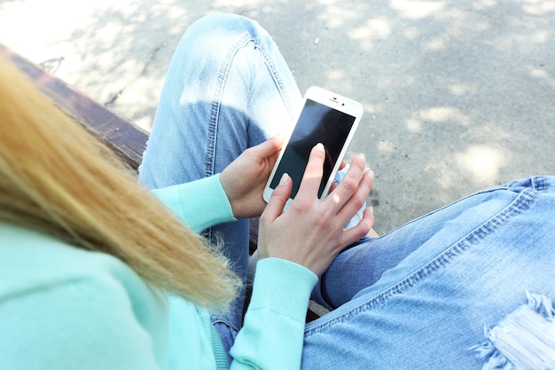 Femme avec téléphone portable à l'extérieur