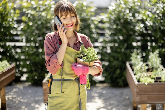 Femme avec téléphone portable à la maison jardin