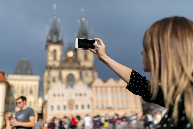 Femme avec un téléphone portable, prenez une photo de la vieille ville de Prague