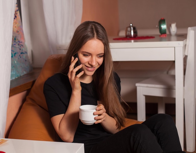 Femme avec téléphone portable et tasse de café