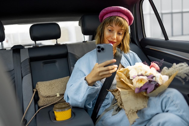 Photo femme avec un téléphone sur le siège arrière d'une voiture