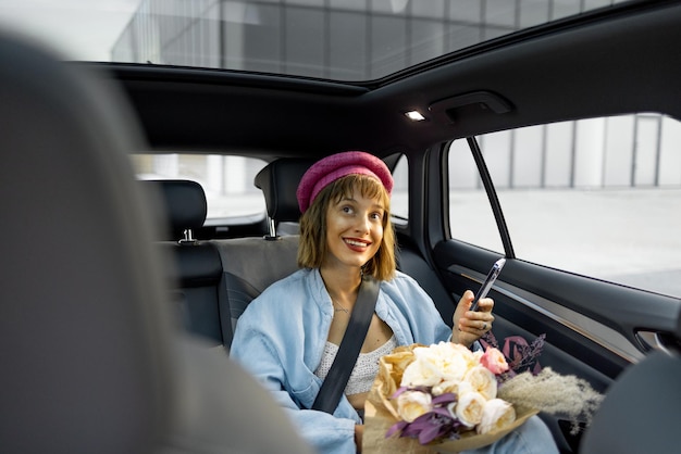Photo femme avec un téléphone sur le siège arrière d'une voiture