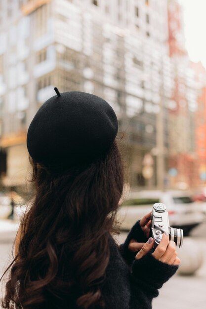 Femme tenant un appareil photo rétro et prenant une photo