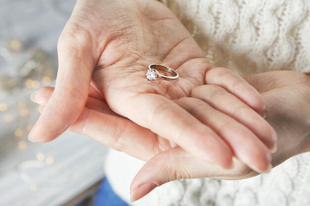 Femme tenant une bague de fiançailles de luxe agrandi