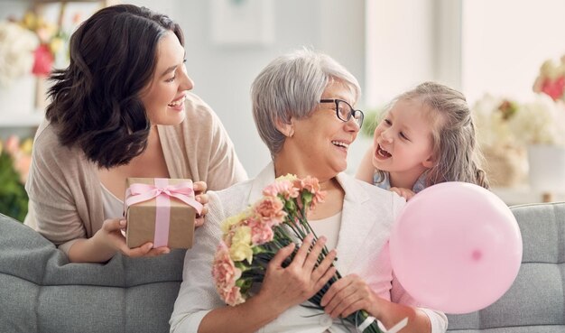 Photo une femme tenant un ballon rose et une petite fille tenant une boîte cadeau rose avec un ruban rose.