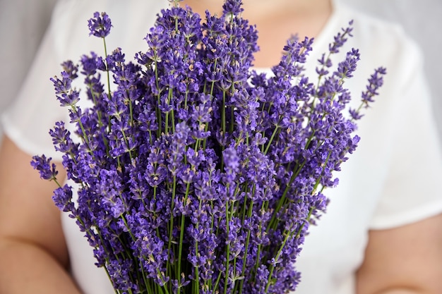 Femme tenant beau bouquet de fleurs de lavande fraîches se bouchent