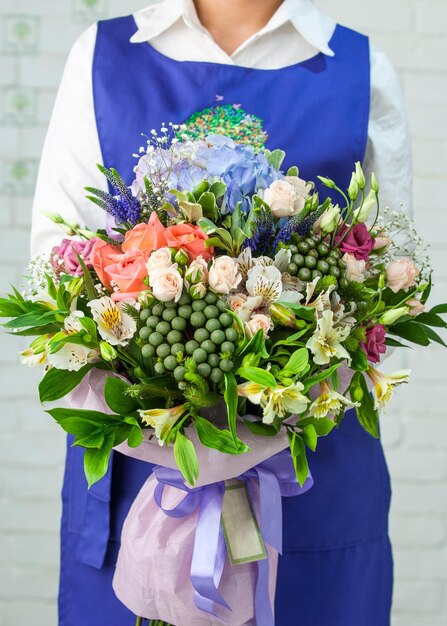 Femme tenant un beau bouquet de roses lisianthus alstroemeria et hortensia