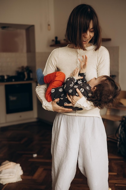 Une femme tenant un bébé dans ses bras dans une cuisine