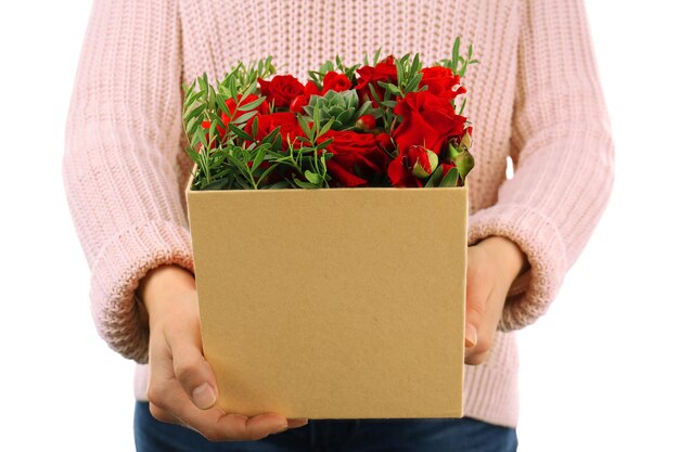 Femme tenant de belles fleurs dans une boîte cadeau sur fond blanc