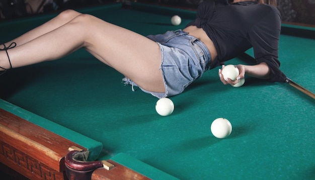 Femme tenant des boules de billard sur la table.