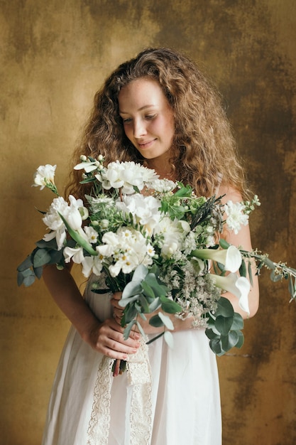Femme tenant un bouquet de fleurs blanches