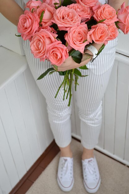 Une femme tenant un bouquet de roses