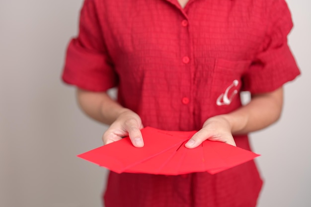 Femme tenant un cadeau d'argent enveloppe rouge chinois pour de bonnes vacances du Nouvel An lunaire