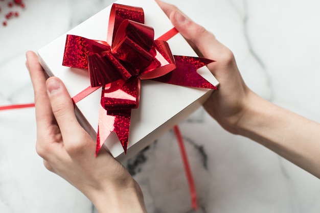 Femme tenant un cadeau de Noël dans ses mains