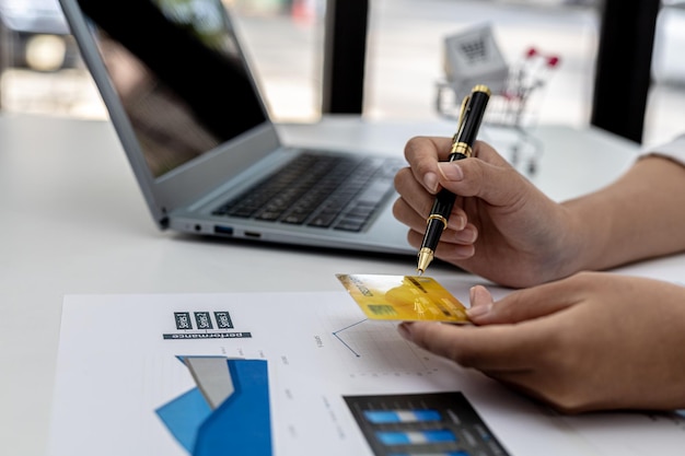 Femme tenant une carte de crédit et tapant sur un clavier d'ordinateur portable, elle remplit les informations de carte de crédit pour payer une commande sur un site d'achat sur Internet. Concept d'achat en ligne et de paiement par carte de crédit