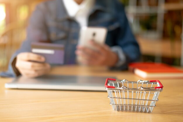 Photo femme tenant une carte de crédit et utilisant un smartphone. concept de magasinage en ligne.