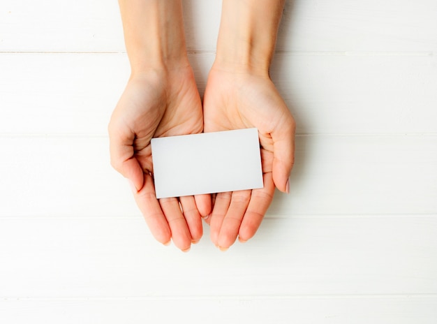 Femme tenant une carte de visite blanche dans les mains. Tamplate pour votre conception.