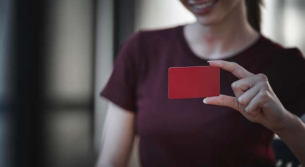 Femme tenant une carte de visite vierge Carte papier rouge pour maquette