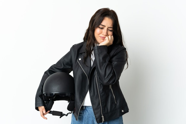 Femme tenant un casque de moto isolé sur fond blanc ayant des doutes