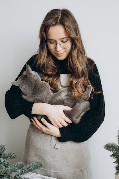 Photo une femme tenant un chat qui a un pull sur lui