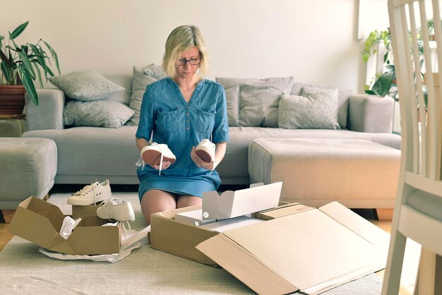 Femme tenant des chaussures alors qu'elle est agenouillée à la maison