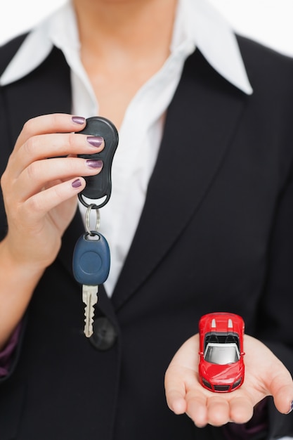 Femme tenant la clé et la petite voiture dans sa paume