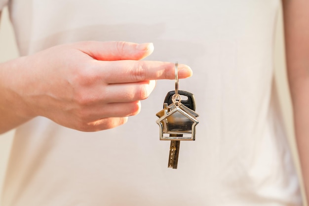 Femme tenant la clé avec porte-clés en forme de maison