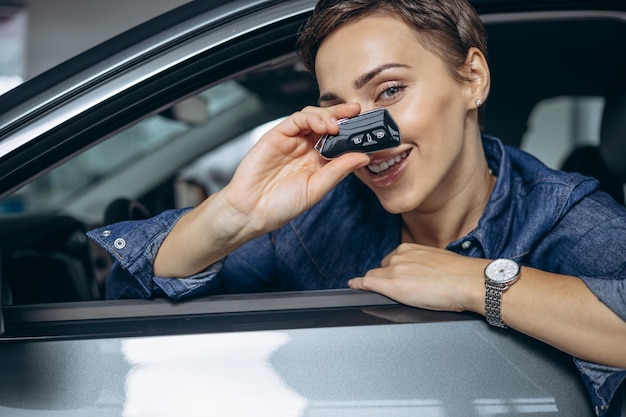 Femme tenant des clés de voiture et reniflant assis dans la voiture