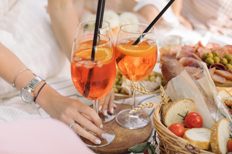 Photo femme tenant un cocktail d'été lors d'un pique-nique dans le parc célébration d'anniversaire en plein air