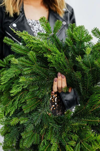 Photo femme tenant une couronne de noël verte