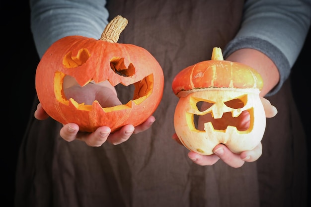 Femme tenant dans la main agrandi de citrouille fraîchement sculpter une citrouille pour Halloween